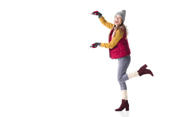 Nainen talvivaatteissa esittää jotain
 - Valokuva, kuva