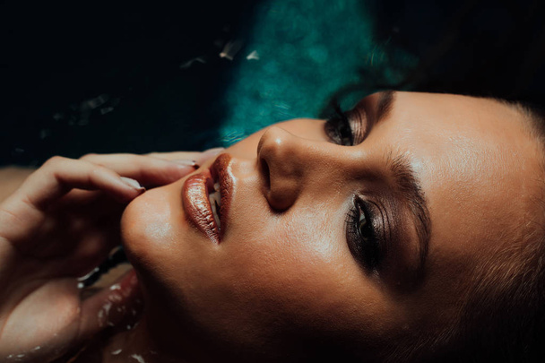 Portrait of beautiful hot woman lies on the water pool. Fingers touch the face sexually. - Fotografie, Obrázek