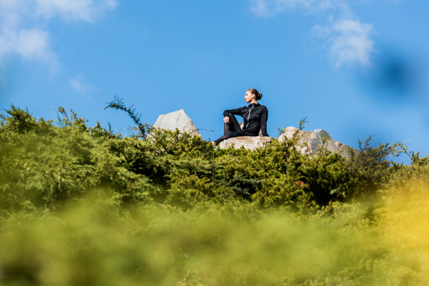 mulher sentada em rochas
 - Foto, Imagem