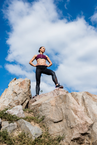 athletic woman standing on rocks - Zdjęcie, obraz