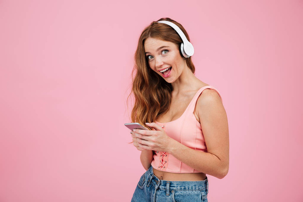 Portrait of an excited happy girl in summer clothes listening music - Foto, Bild