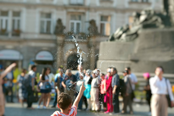 7 años de edad, niño en camiseta roja soplar burbuja jabón en la ciudad. Niñez feliz concepción
 - Foto, Imagen