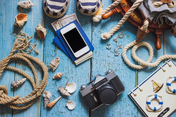 Camera, phone and maritime decorations on the wooden background - Foto, Imagem