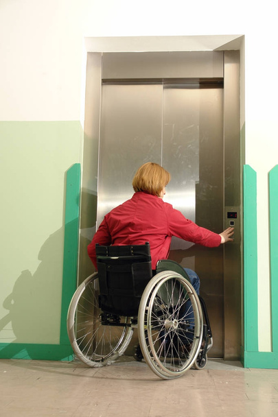 Жінка з обмеженими можливостями використовує ліфт
 - Фото, зображення