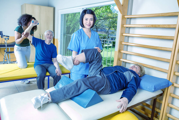 Активные пожилые люди в помещении спортзала с помощью медсестер
 - Фото, изображение