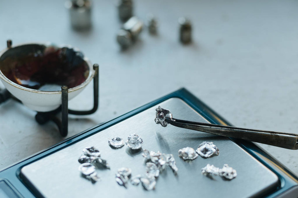Jewelry tools. Jewellery. Goldsmith workplace, workspace on light background. Hand craft. Workshop. Manufacturing. Weigh-scales with granules of metal silver and platinum. Closeup. Toned - Photo, Image