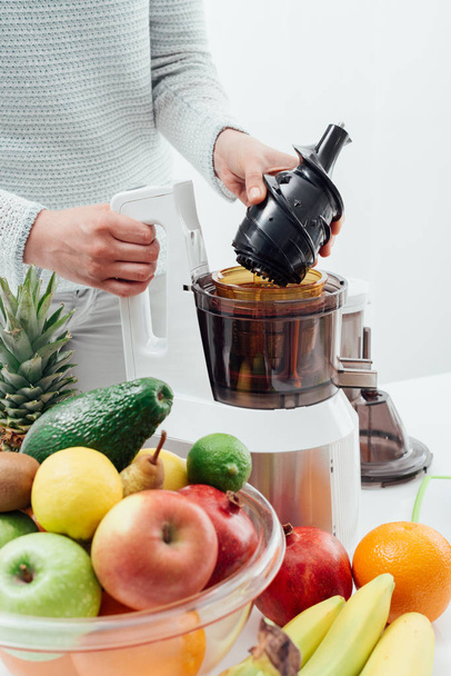 Woman using a juice extractor - Foto, afbeelding
