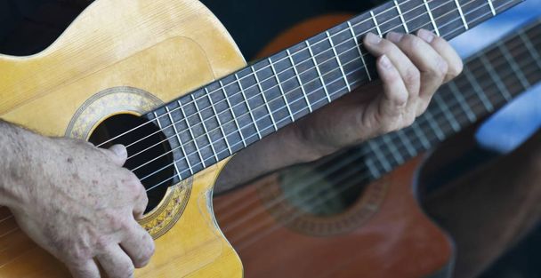 Een muzikant speelt een Cutaway klassieke gitaar - Foto, afbeelding
