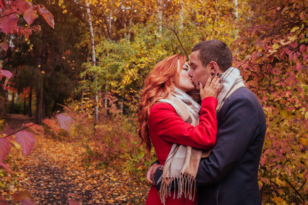 Young couple kisses in autumn forest among - Photo, Image