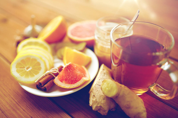ginger tea with honey, citrus and cinnamon on wood - Fotografie, Obrázek