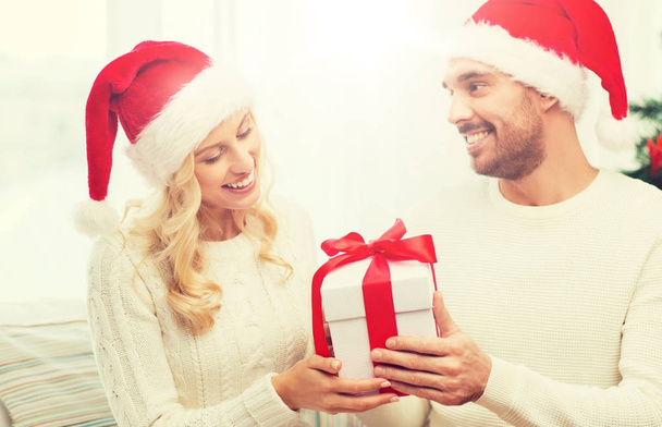 happy couple at home with christmas gift box - Foto, afbeelding