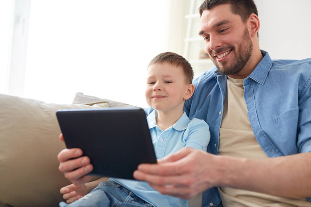 father and son with tablet pc playing at home - 写真・画像