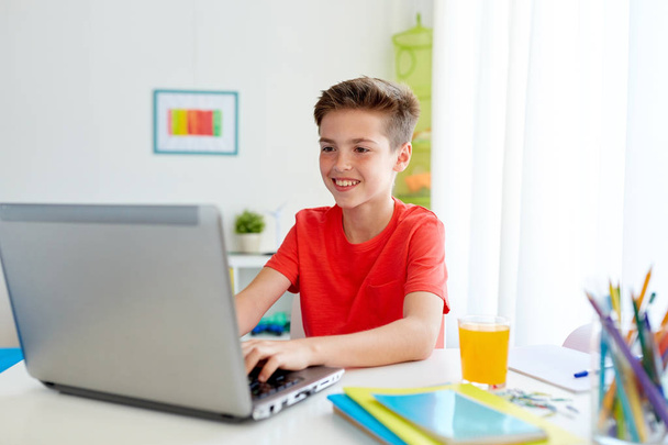 student boy typing on laptop computer at home - Photo, Image
