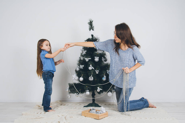 Mother and little daughter decorating christmas tree  - Valokuva, kuva