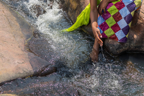 Γυναίκα στην αφρικανική στολή στα πρόθυρα της άπταιστα ποταμού. Interactin - Φωτογραφία, εικόνα