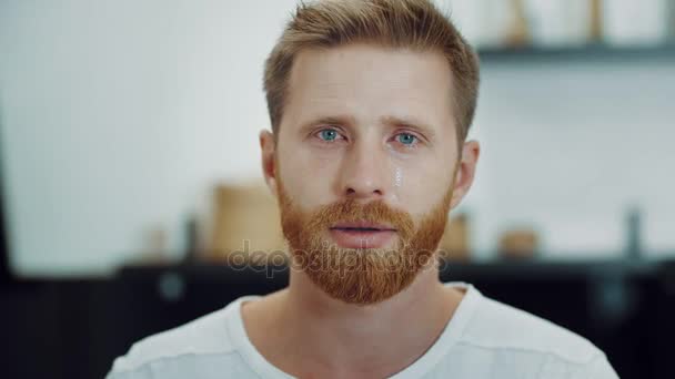 Crying tears in eyes of depressed ginger man - Materiał filmowy, wideo