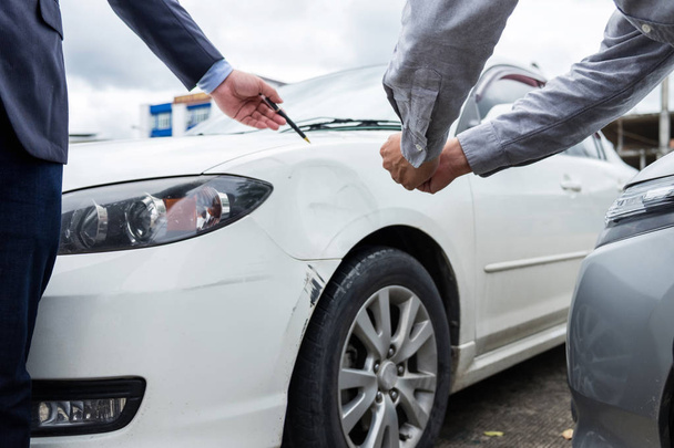 Insurance Agent examine Damaged Car and filing Report Claim Form - Фото, изображение
