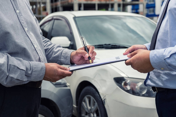 Insurance Agent examine Damaged Car and customer filing signatur - Fotoğraf, Görsel
