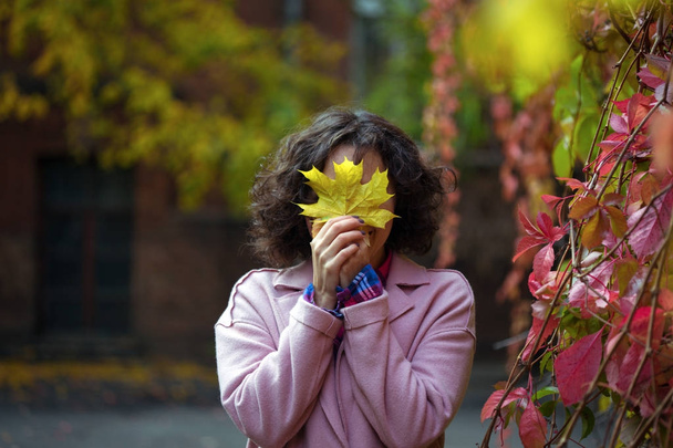 girl holds a yellow leaf - Fotó, kép