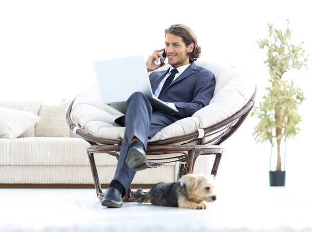 business man talking on a smartphone sitting in the living room - Foto, imagen