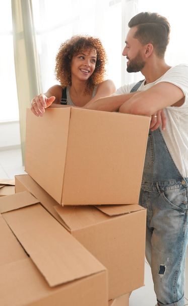 Happy couple standing near boxes in their new apartment. - Foto, immagini