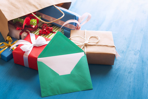 Відкритий конверт і сумка повні подарунків
 - Фото, зображення
