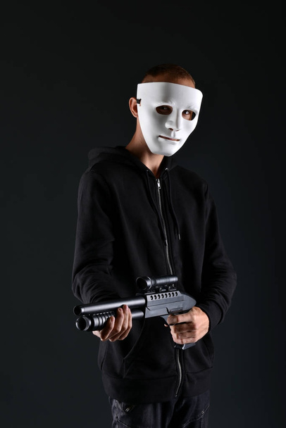 Delincuente enmascarado sosteniendo un arma - Foto, imagen