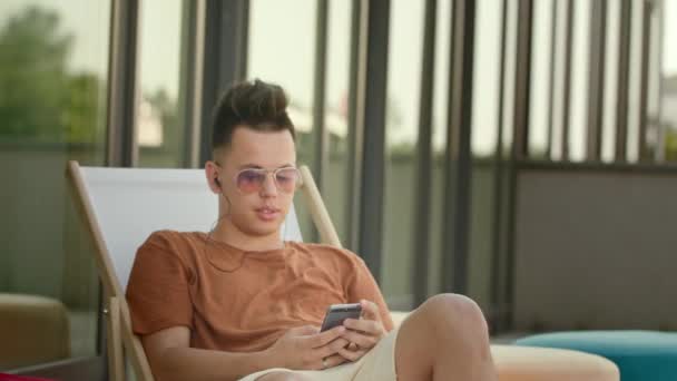 A Young Man Using a Smartphone on the Terrace. - Felvétel, videó