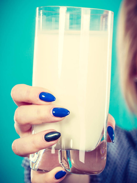 Woman hand holding glass of milk - Foto, afbeelding