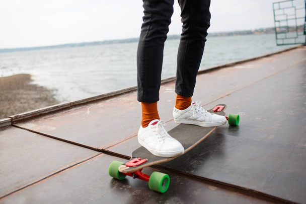 The guy on the pier is riding skateboard - 写真・画像