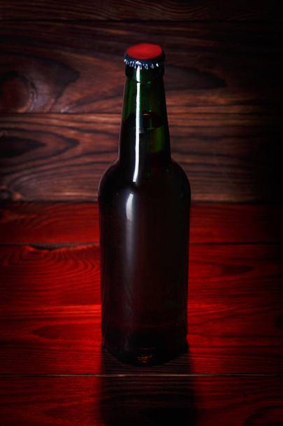Bottles with beer on a brown wooden background - Foto, afbeelding