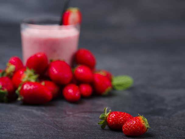 Sweet fresh strawberries jogurt in a glass on a gray background. Food concept. - Фото, изображение