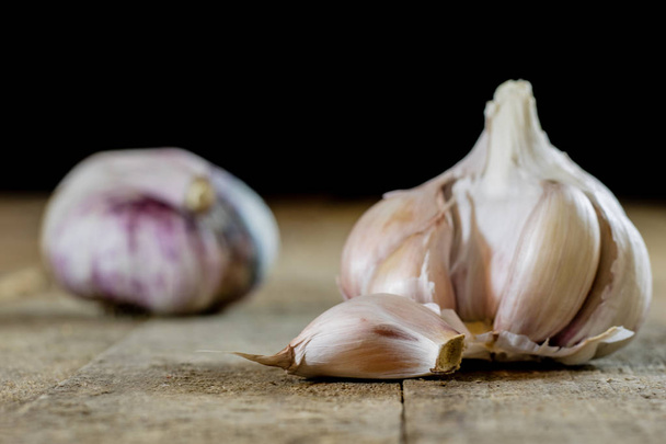 Tasty garlic on a wooden kitchen table. Vegetables in the kitche - Photo, Image
