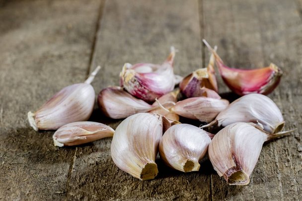 Tasty garlic on a wooden kitchen table. Vegetables in the kitche - Zdjęcie, obraz