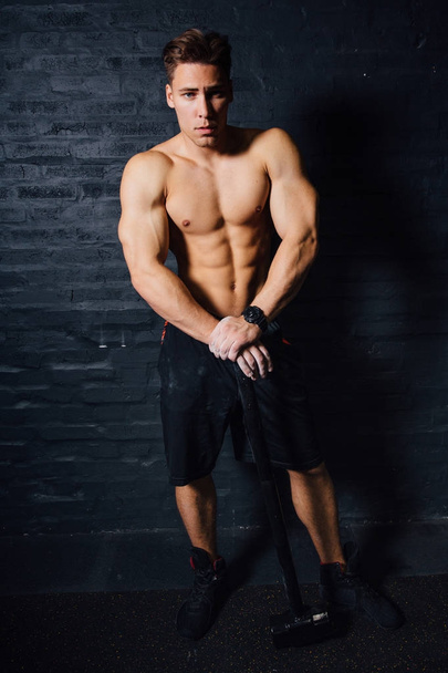 portrait of a young physically fit man workout at gym with hammer. muscular athletic . - Foto, Imagem