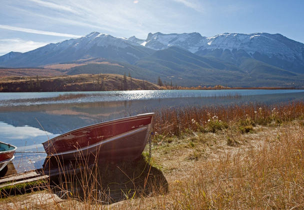 red boat on a lake by mountains - Photo, Image