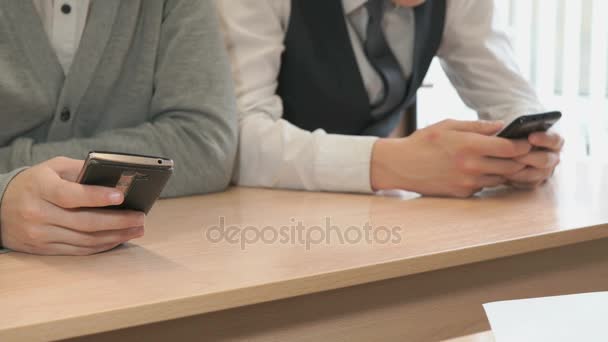 Two students holding smartphones - Πλάνα, βίντεο