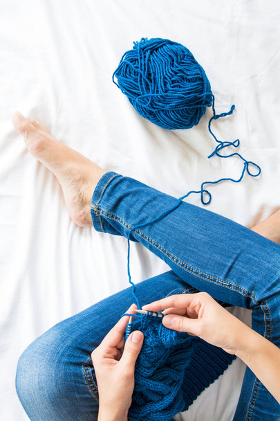 Woman knitting blue sweater. Overhead shot - Fotografie, Obrázek