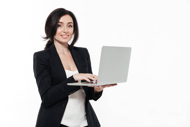 Portrait of a happy smiling businesswoman in a suit typing - Zdjęcie, obraz