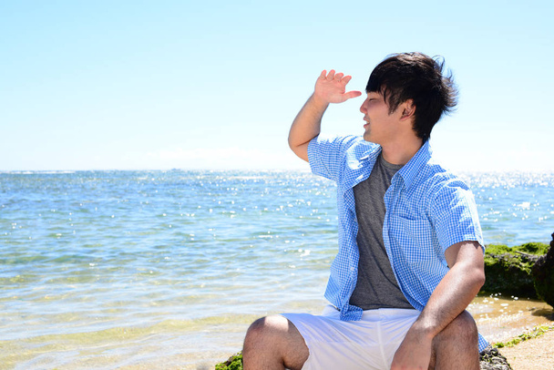 Souriant asiatique homme sur la plage - Photo, image