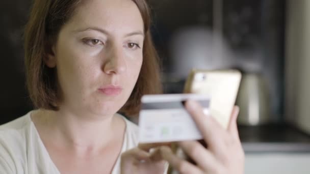 Dziewczyna wchodzi numer karty kredytowej na smartfonie - Materiał filmowy, wideo