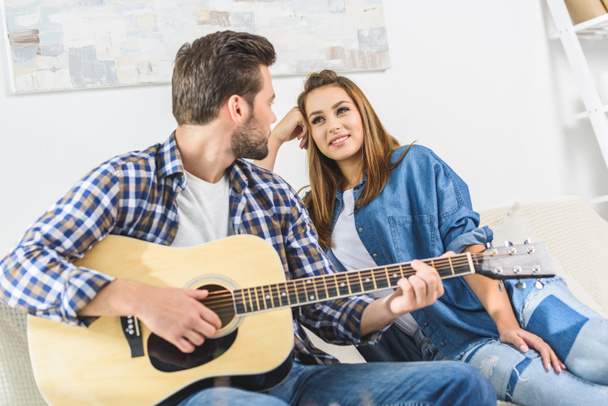 Casal no sofá com guitarra
 - Foto, Imagem