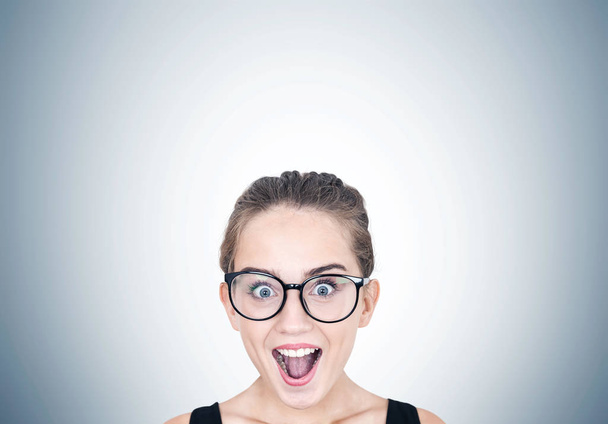 Astonished girl in round glasses, gray - Foto, afbeelding