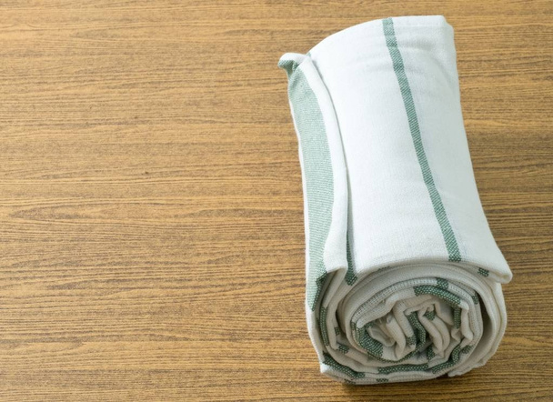 Ręcznik kuchenny biały i zielony na drewnianym stole - Zdjęcie, obraz