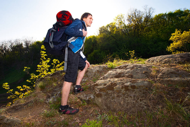 egy fiatal férfi, túrázás az erdőben. Utazás, túrázás, hátizsákkal, a turizmus és a fő koncepció - Fotó, kép