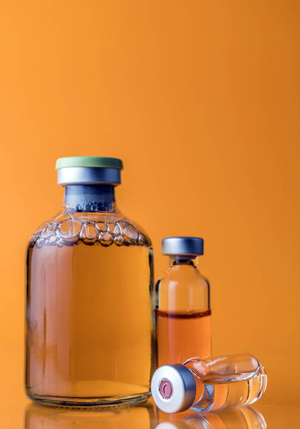 Médicament en flacons, prêt pour l'injection de vaccin isolé sur fond orange
 - Photo, image