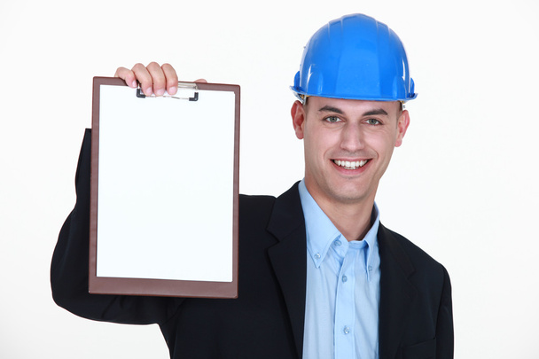 Businessman wearing helmet and holding a notepad - Foto, immagini