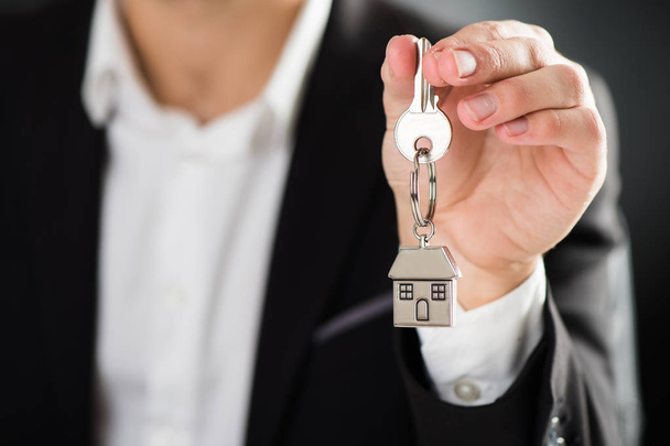 key chain with key in hand of a real estate agent - Photo, Image