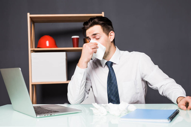 бизнесмен с простудой в голове и сидя на рабочем месте офиса
 - Фото, изображение