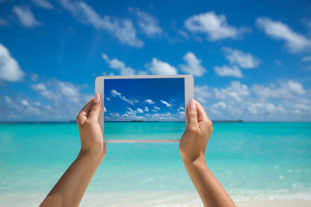 Woman holding tablet computer with screen on the tropical sea. t - Foto, immagini